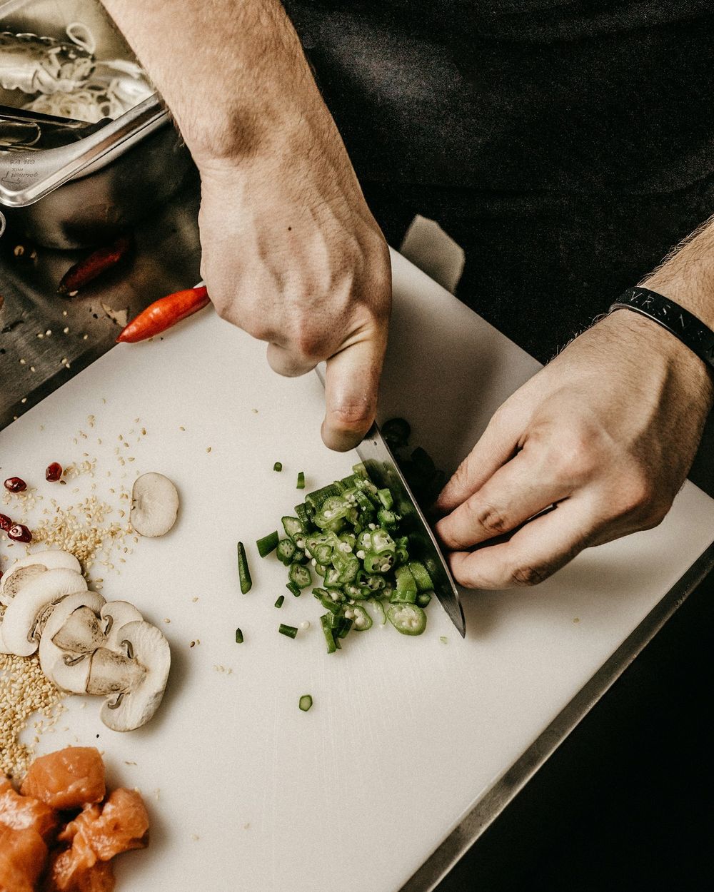 Mãos do chef finalizando um prato